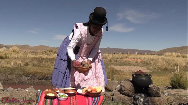 Al aire libre, en medio del campo, la Cholita Julia inicia a su estilo su nuevo video.