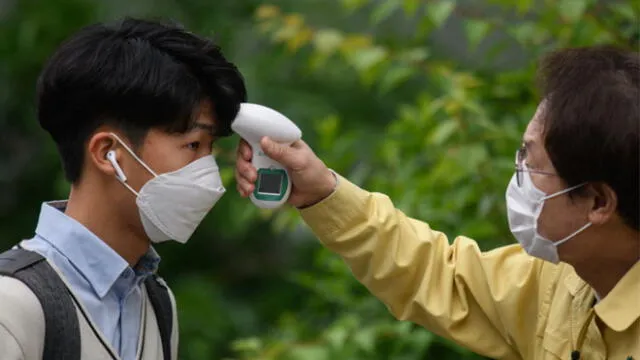 Un estudiante se somete a un control de temperatura por la pandemia de coronavirus en Corea del Sur. Foto: AFP