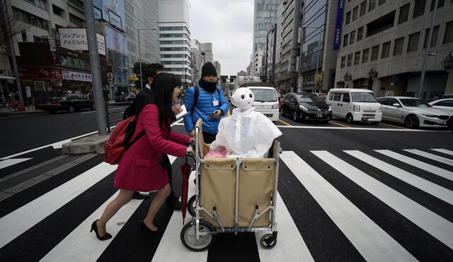 En Tokio, una mujer empuja un carrito con su robot humanoide Pepper.