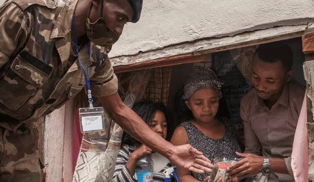 Soldados entregan gratuitamente a la familias una "cura" contra el coronavirus. Foto: AFP