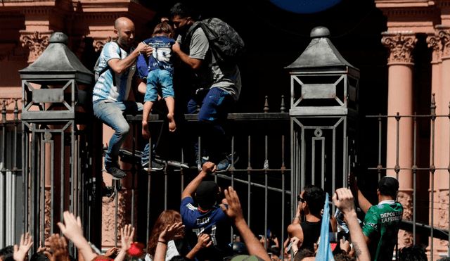Los hinchas trepan las rejas para ingresar al velatorio de Diego Maradona. Foto: Infobae
