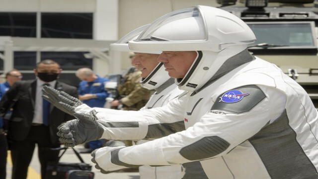 This handout photo released by NASA shows NASA astronauts Douglas Hurley, left, and Robert Behnken, wearing SpaceX spacesuits, give their families virtual hugs as they prepare to depart the Neil A. Armstrong Operations and Checkout Building for Launch Complex 39A to board the SpaceX Crew Dragon spacecraft for the Demo-2 mission launch, Wednesday, May 27, 2020, at NASA�s Kennedy Space Center in Florida. - NASA�s SpaceX Demo-2 mission is the first launch with astronauts of the SpaceX Crew Dragon spacecraft and Falcon 9 rocket to the International Space Station as part of the agency�s Commercial Crew Program. The test flight serves as an end-to-end demonstration of SpaceX�s crew transportation system. Behnken and Hurley are scheduled to launch at 4:33 p.m. EDT on Wednesday, May 27, from Launch Complex 39A at the Kennedy Space Center. A new era of human spaceflight is set to begin as American astronauts once again launch on an American rocket from American soil to low-Earth orbit for the first time since the conclusion of the Space Shuttle Program in 2011. (Photo by Bill INGALLS / NASA / AFP) / RESTRICTED TO EDITORIAL USE - MANDATORY CREDIT "AFP PHOTO /NASA/Bill Ingalls  " - NO MARKETING - NO ADVERTISING CAMPAIGNS - DISTRIBUTED AS A SERVICE TO CLIENTS