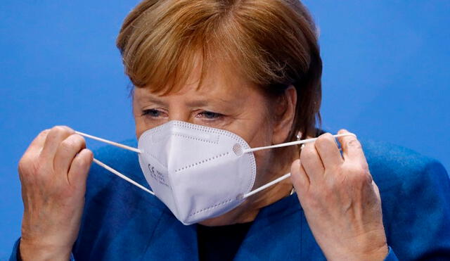 La canciller, Angela Merkel, se coloca el cubrebocas antes de la conferencia de prensa del miércoles 28 de octubre. Foto: AFP
