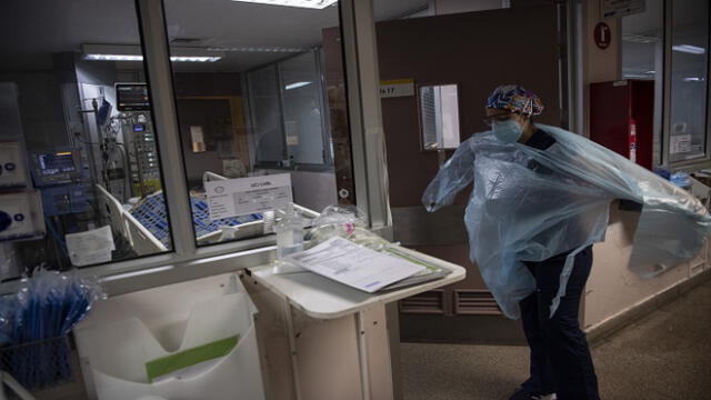 A doctor puts a protective gown as she gets ready to check patients at the Intensive Care Unit of the Barros Luco Hospital in Santiago, on July 22, 2020 amid the COVID-19 novel coronavirus pandemic. (Photo by Martin BERNETTI / AFP)