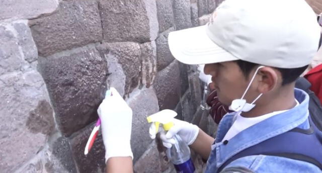 Estudiantes limpian muros incas deteriorados durante las fiestas de Cusco