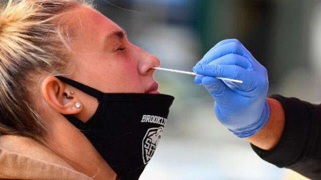 Un trabajador médico toma una muestra de un hisopo nasal de un estudiante para realizar una prueba de COVID-19 en Estados Unidos. Foto: AFP