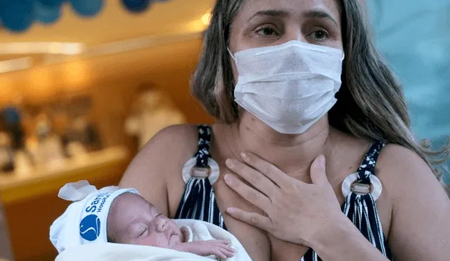 Rusia Goes lleva a su hija Luisa en brazos luego de ser dada de alta del hospital en Río de Janeiro, Brasil. | Foto: Ricardo Moraes / Reuters.