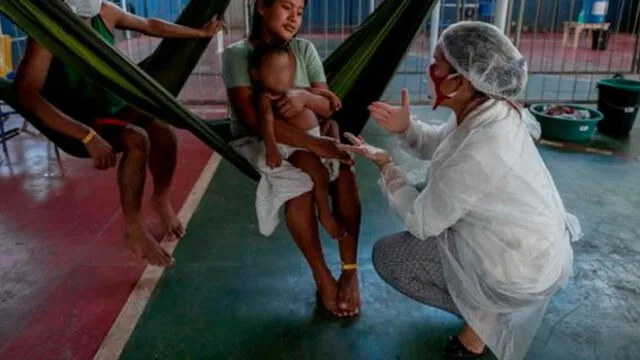 Una trabajadora médica habla con una mujer indígena en un albergue de Brasil. Foto: AFP.