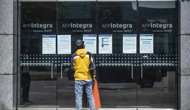 A man looks for information at the front door of Integra AFP (Pension Fund Administration) office in Lima on May 18, 2020. - More than six million Peruvians can request as of Monday the withdrawal of up to 3,700 US dollars from their pension funds to alleviate the economic crisis caused during the two months lockdown imposed by the government to fight the spread of the novel Covid-19 coronavirus. (Photo by Ernesto BENAVIDES / AFP)