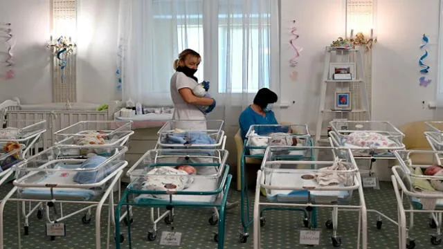 Nurses care for newborn babies at Kiev's Venice hotel on May 15, 2020. - More than 100 babies born to surrogate mothers have been stranded in Ukraine as their foreign parents cannot collect them due to border closures imposed during the coronavirus pandemic, authorities said on May 14. (Photo by Sergei SUPINSKY / AFP)