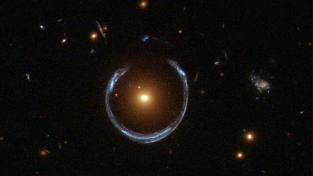 Imagen de una galaxia que distorsiona la luz de otra más lejana, efecto conocido como lente gravitacional, descartado como posible origen de los objetos. Crédito: NASA.