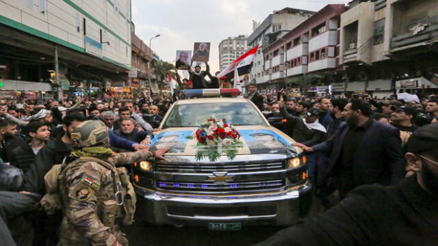 Mourners surround a car carrying the coffins of Iranian military commander Qasem Soleimani and Iraqi paramilitary chief Abu Mahdi al-Muhandis, killed in a US air strike, during their funeral procession in Kadhimiya, a Shiite pilgrimage district of Baghdad, on January 4, 2020. - Thousands of Iraqis chanting "Death to America" joined the funeral procession Saturday for Iranian commander Qassem Soleimani and Iraqi paramilitary chief Abu Mahdi al-Muhandis, both killed in a US air strike. The cortege set off around Kadhimiya, a Shiite pilgrimage district of Baghdad, before heading to the Green Zone government and diplomatic district where a state funeral was to be held attended by top dignitaries. In all, 10 people -- five Iraqis and five Iranians -- were killed in Friday morning's US strike on their motorcade just outside Baghdad airport. (Photo by SABAH ARAR / AFP)