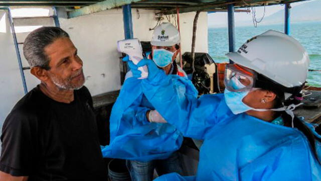 Foto publicada por el Ministerio de Salud de Panamá muestra a miembros del ministerio que controlan la temperatura de un miembro de la tripulación de un barco ecuatoriano. Foto: AFP.