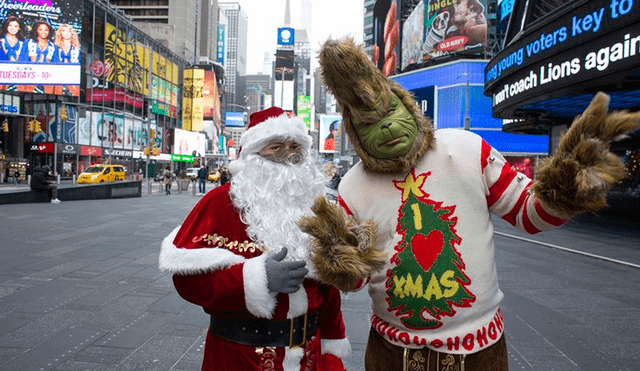 Un hombre vestido como Santa Claus junto a otro disfrazado como Mr. Grinch en Times Square, Estados Unidos. Foto: AFP