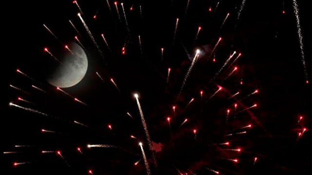 Alemania. La luna en medio de fuegos artificiales que celebraban el eclipse. Foto: EFE.