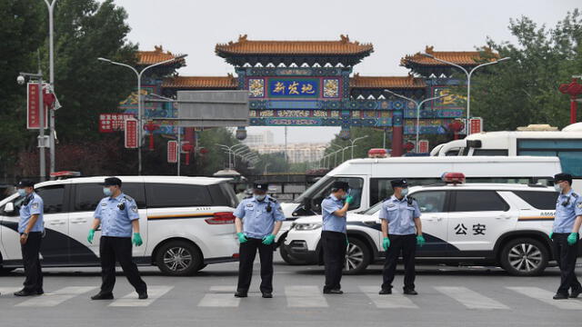 Chinese police guard the entrance to the closed Xinfadi market in Beijing on June 13, 2020. - Eleven residential estates in south Beijing have been locked down due to a fresh cluster of coronavirus cases linked to the Xinfadi meat market, officials said on June 13. (Photo by GREG BAKER / AFP)