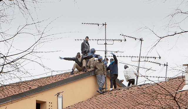 Rebelión. Detenidos protestan en los techos de la prisión de San Vittore en Milán pidiendo una amnistía debido a la emergencia sanitaria que generó el virus. Foto: EFE.