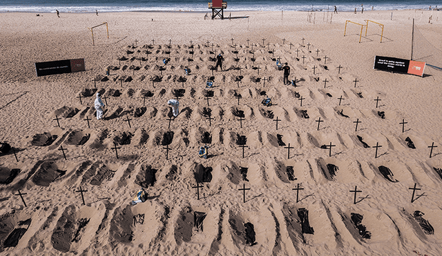 Vista aérea de activistas de la ONG Río de Paz cavando las tumbas en la playa de Copacabana. | Foto: Carl de Souza / AFP