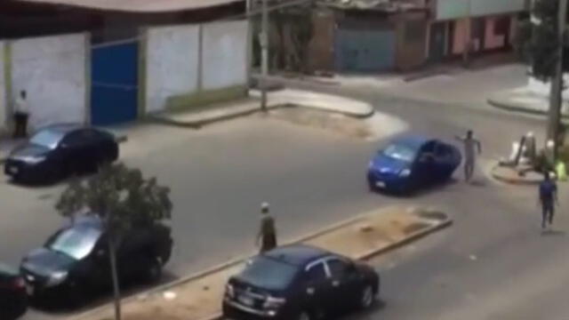 Uno de los presuntos extorsionadores se esconde detrás de auto mientras dispara. (Foto: Captura de video / Latina Noticias)