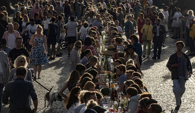 En el famoso puente del siglo XIV, los participantes trajeron comida y bebida de sus casas para compartirlas a lo largo de una mesa de 500 metros de longitud. Foto: AFP.