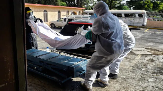 Workers unload the corpse of s suspected COVID-19 victim from a hearse at the San Isidro Pantheon in Azcapotzalco, Mexico City, on June 10, 2020. (Photo by ALFREDO ESTRELLA / AFP)