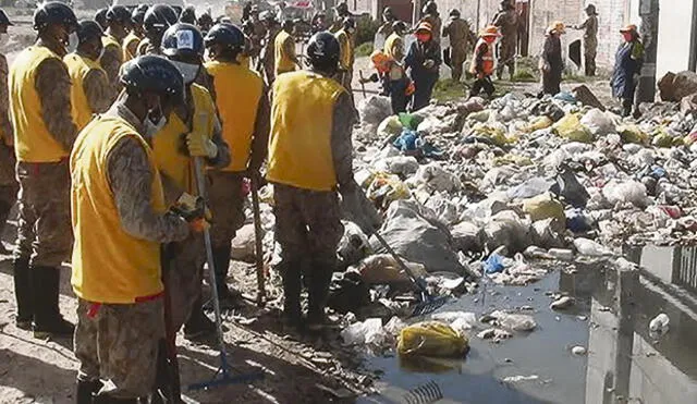 Soldados ayudan a limpiar la basura de calles de Juliaca