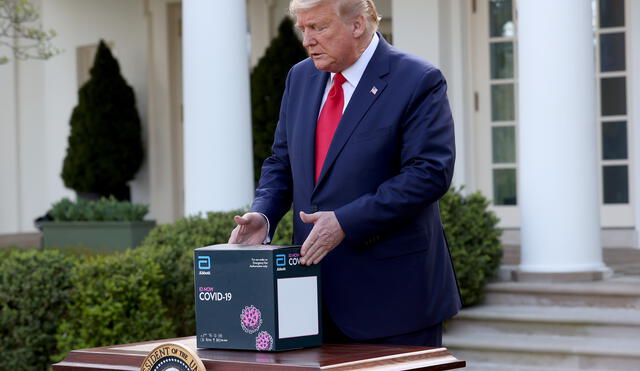 Donald Trump muestra dispositivo que realiza prueba PCR en 5 minutos. Crédito: AFP