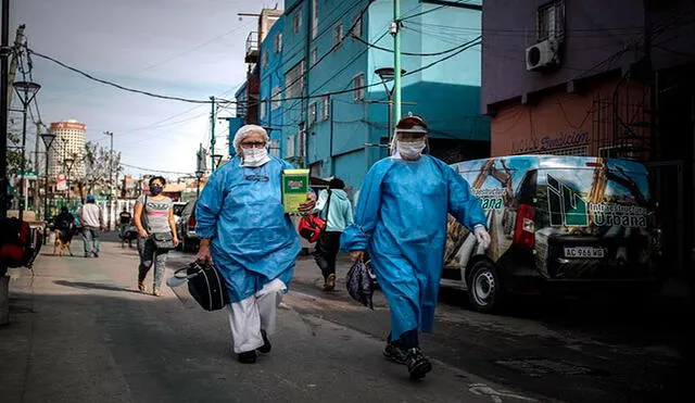 Personal sanitario con trajes de protección caminaban el viernes en la Villa 31 en la ciudad de Buenos Aires. Foto: EFE