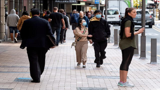 People walk on a street in Wellington on May 14, 2020. - New Zealand will phase out its coronavirus lockdown over the next 10 days after successfully containing the virus, although some restrictions will remain, Prime Minister Jacinda Ardern announced on May 11. Ardern said that from May 14 shopping malls, restaurants, cinemas and playgrounds will reopen -- with the country moving to Level Two on its four-tier system. (Photo by Marty MELVILLE / AFP)