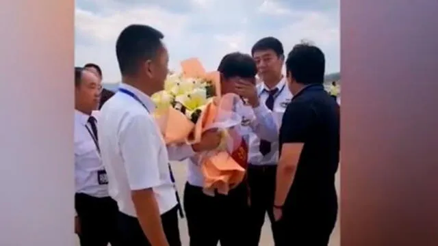 En el video publicado por China Eastern Airlines se ve al veterano piloto llorar mientras se despedía de pasajeros y colegas. Captura de video.