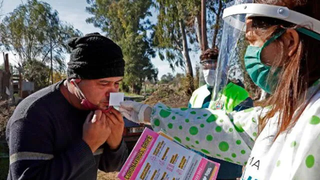 Un trabajador de la salud realiza una prueba olfativa a un residente en el barrio Altos de San Lorenzo, cerca de la ciudad de La Plata en Argentina. Foto: Alejandro Pagni/AFP.
