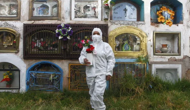 Carol Velazquez tiene en el cementerio Laykakota a sus padres y abuelos, vestida con su traje de bioseguridad es consciente que esta pandemia aun no se va y no debemos confiarnos. Foto: Juan Carlos Cisneros / La República