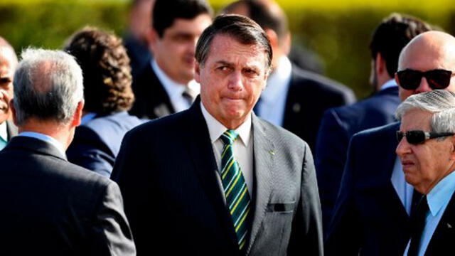 El presidente brasileño, Jair Bolsonaro, asiste a la ceremonia de izamiento de la bandera nacional antes de una reunión ministerial en el Palacio de la Alvorada. Foto: AFP