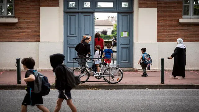 Parents and children enter the Jules Julien elementary school in Toulouse, southern France, on June 22, 2020 following the reopening of schools as France eases lockdown measures taken to curb the spread of the COVID-19 (the novel coronavirus). (Photo by Lionel BONAVENTURE / AFP)