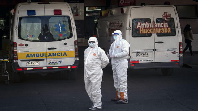 Health workers stand next to an ambulance carrying a patient with symptoms of the new COVID-19 coronavirus while waiting for admission outside a hospital, amid the spread of the coronavirus disease (COVID-19) in Santiago, on June 05, 2020. - Deaths from the coronavirus in Chile have risen by more than 50 percent in the past week, the health ministry announced Friday, despite a three-week lockdown of the capital Santiago. Three months after the country registered its first infection, Health Minister Jaime Manalich reported 4,207 new infections and 92 deaths in the previous 24 hours. (Photo by MARTIN BERNETTI / AFP)