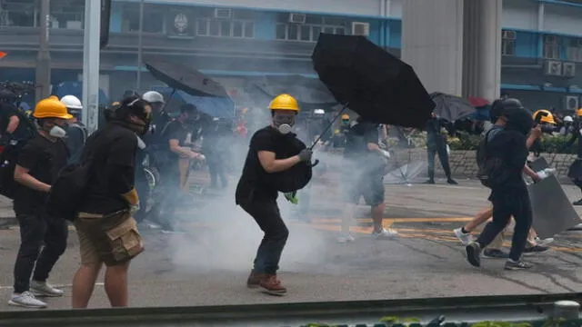 Manifestantes devuelven granadas de gas lacrimógeno lanzadas por la policía durante un enfrentamiento en el distrito de Yuen Long, Hong Kong. Foto:_ AP