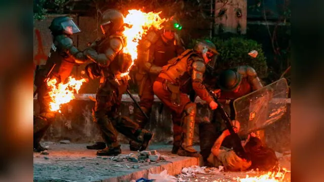 Un grupo de policías fue atacado con bombas molotov en medio de las protestas en Chile. Foto: AFP