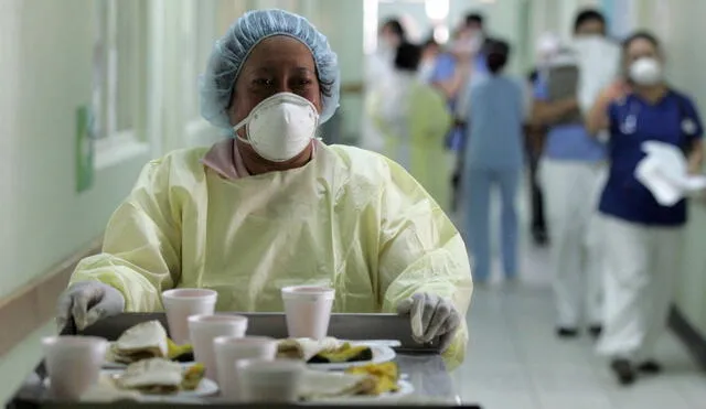 Una funcionaria del Hospital Roosevelt de Ciudad de Guatemala reparte la comida a los enfermos de Cuidados Intensivos. Foto: AFP.
