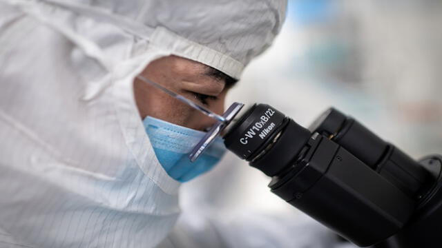 In this picture taken on April 29, 2020, an engineer looks through a microscope at monkey kidney cells as he checks tests on an experimental vaccine for the COVID-19 coronavirus inside the Cells Culture Room laboratory at the Sinovac Biotech facilities in Beijing. - Sinovac Biotech, which is conducting one of the four clinical trials that have been authorised in China, has claimed great progress in its research and promising results among monkeys. (Photo by NICOLAS ASFOURI / AFP) / TO GO WITH Health-virus-China-vaccine,FOCUS by Patrick Baert