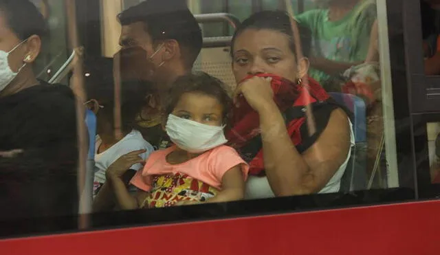 Una mujer y su hija observan desde la ventana de un autobús mientras son llevadas con un grupo de venezolanos de regreso a su casa luego de cumplir con la cuarentena en la frontera con Colombia. Foto: EFE
