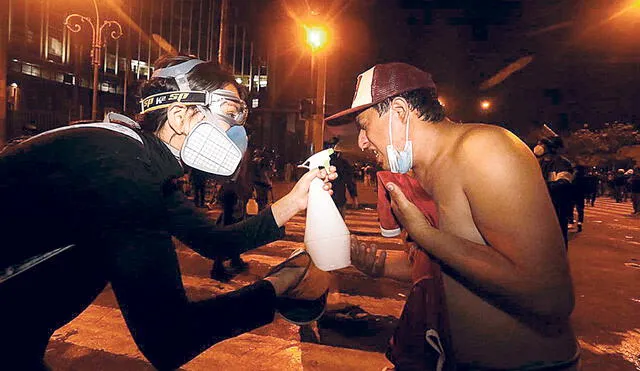 Solidaridad. Manifestante ayuda a otro a librarse del gas. Foto: Oswald Charca/La República