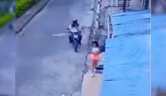 El depravado a bordo de una moto dobla la esquina en dirección de la niña y disminuye la velocidad para manosearla. Foto: Captura