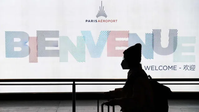 Un pasajero proveniente de China, sale de la Terminal con una máscara de papel después de aterrizar en el aeropuerto Charles De Gaulle el 26 de enero de 2020.