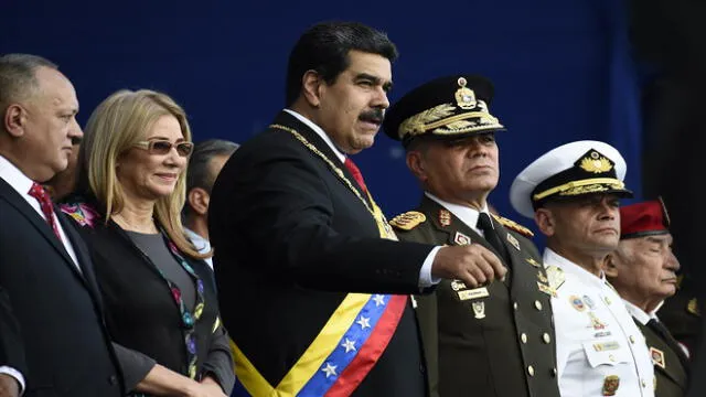 Venezuela's President Nicolas Maduro speaks with Venezuela's Defence Minister General Vladimir Padrino during the ceremony in which the Bolivarian National Armed Forces (FANB) recognize him after his inauguration for a second term, at the Fuerte Tiuna Military Complex, in Caracas on January 10, 2019. - Maduro begins a new term that critics dismiss as illegitimate, with the economy in free fall and the country more isolated than ever. (Photo by Federico Parra / AFP)