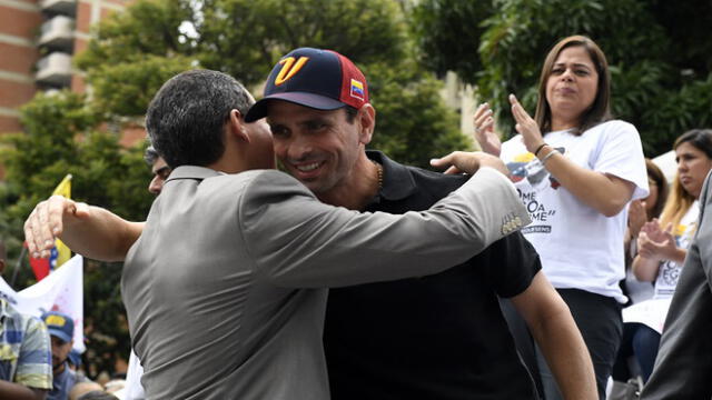 Venezuelan opposition leader and self-proclaimed acting President Juan Guaido (L) embraces the former Governor of Miranda (2008�2017) Henrique Capriles Radonski during a demo to demand jailed Venezuelan Deputy Juan Requesens be freed in Caracas on August 7, 2019, a year after his detention. (Photo by Federico Parra / AFP)