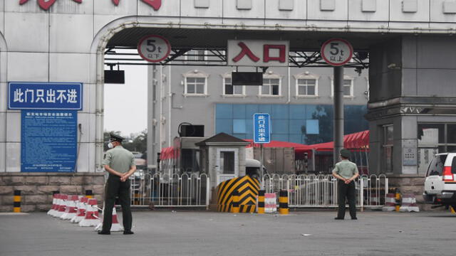 Chinese paramilitary police officers guard an entrance to the closed Xinfadi market in Beijing on June 13, 2020. - The huge wholesale market has become the centre of focus for a new cluster of coronavirus cases in Beijing, where nervous local officials have begun mass testing, closing schools and neighbourhoods, and turned sharp scrutiny towards the food supply chain. (Photo by GREG BAKER / AFP)