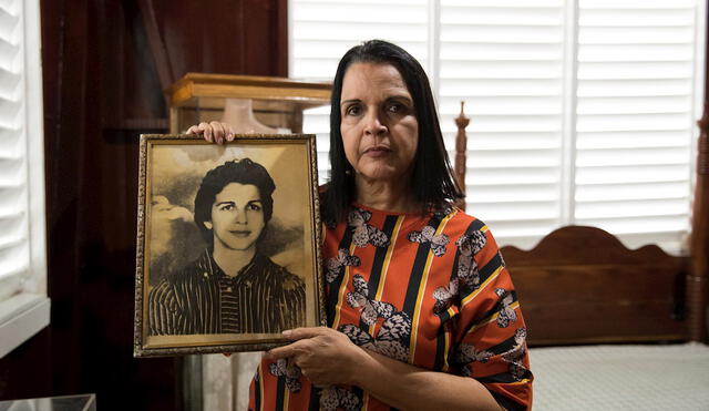 Minou Tavárez Mirabal, hija de Minerva y de Manolo Tavárez, héroes antitrujillistas, posa con el retrato de su madre. Foto: EFE