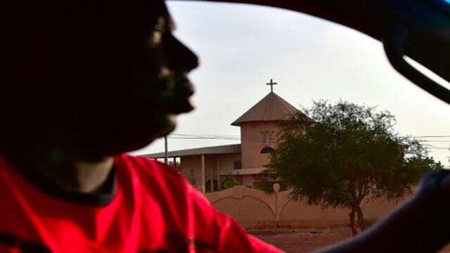 Un hombre conduce su auto frente a una iglesia en la ciudad de Ouahigouya, en el norte de Burkina Faso, el 30 de octubre de 2018. Foto: AFP