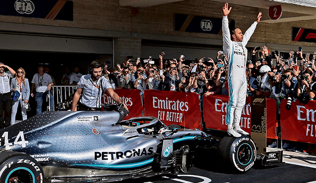 Emocionado. Hamilton celebra sobre un neumático de su coche.