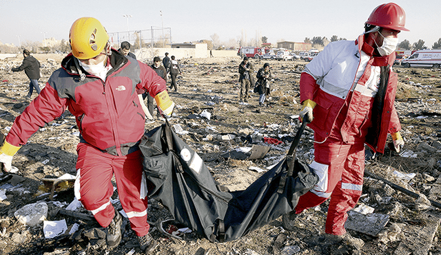 Emergencia. Brigadistas recogen los restos del accidente aéreo cerca de Teherán. Foto: EFE.